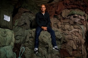 Kelly Slater on top of recycled fishing nets in a factory in Slovenia. Photo by Todd Glaser.